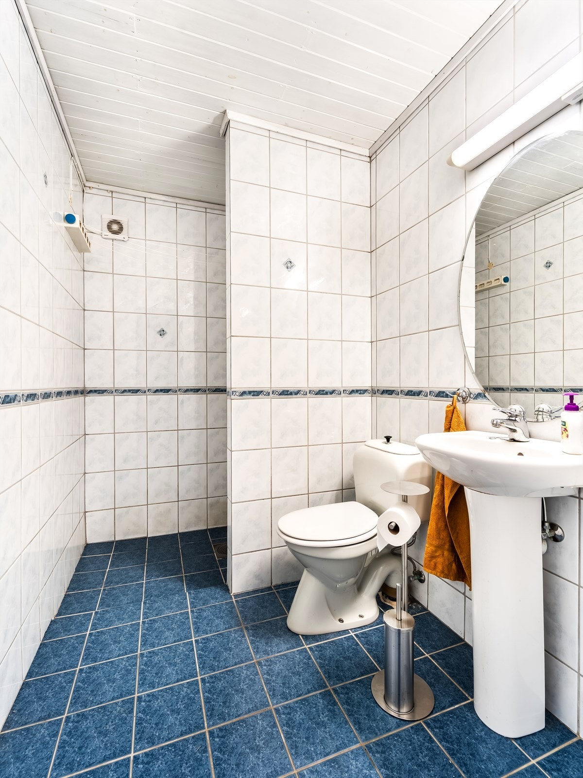 Bad i underetasjen med fliser på gulv og vegger. Innredet med servant med speil, toalett og dusjløsning. Galleribilde