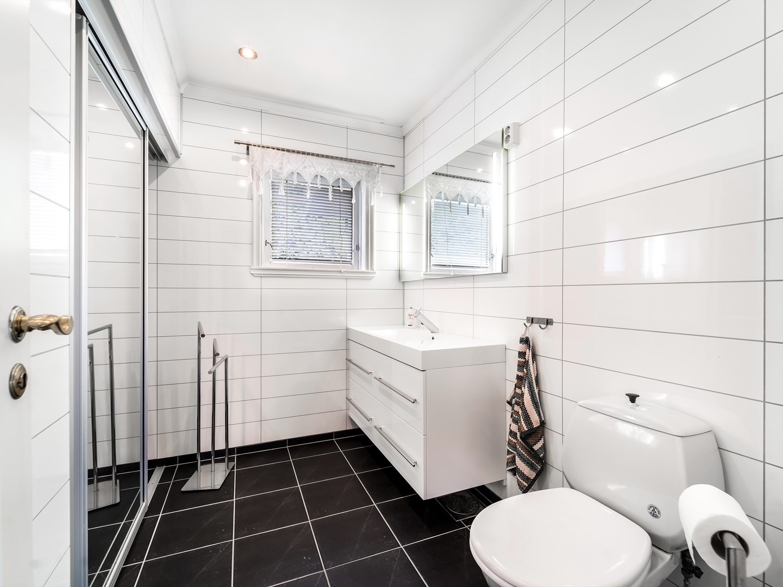 Fliselagt bad i 1. etasje med skyvedørsgarderobe. Galleribilde