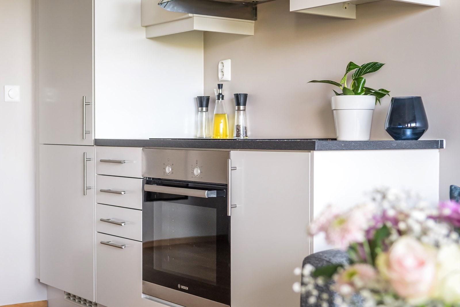 Kjøkkenets integrerte hvitevarer består av kjøl-/fryseskap, induksjonstopp, stekeovn og ventilator over kokeplass. Galleribilde