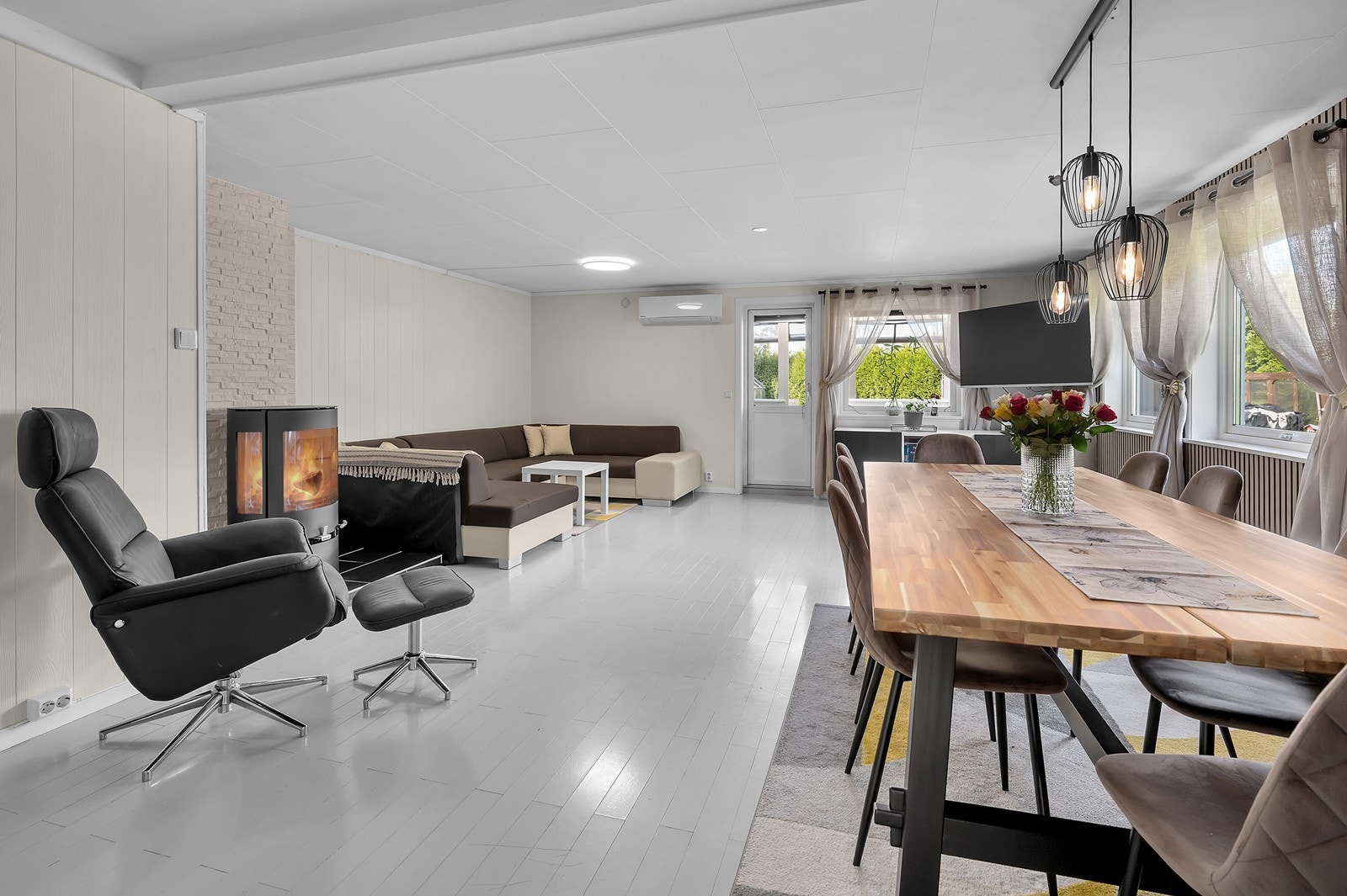 Lys og innbydende stue med varmepumpe og peisovn Galleribilde