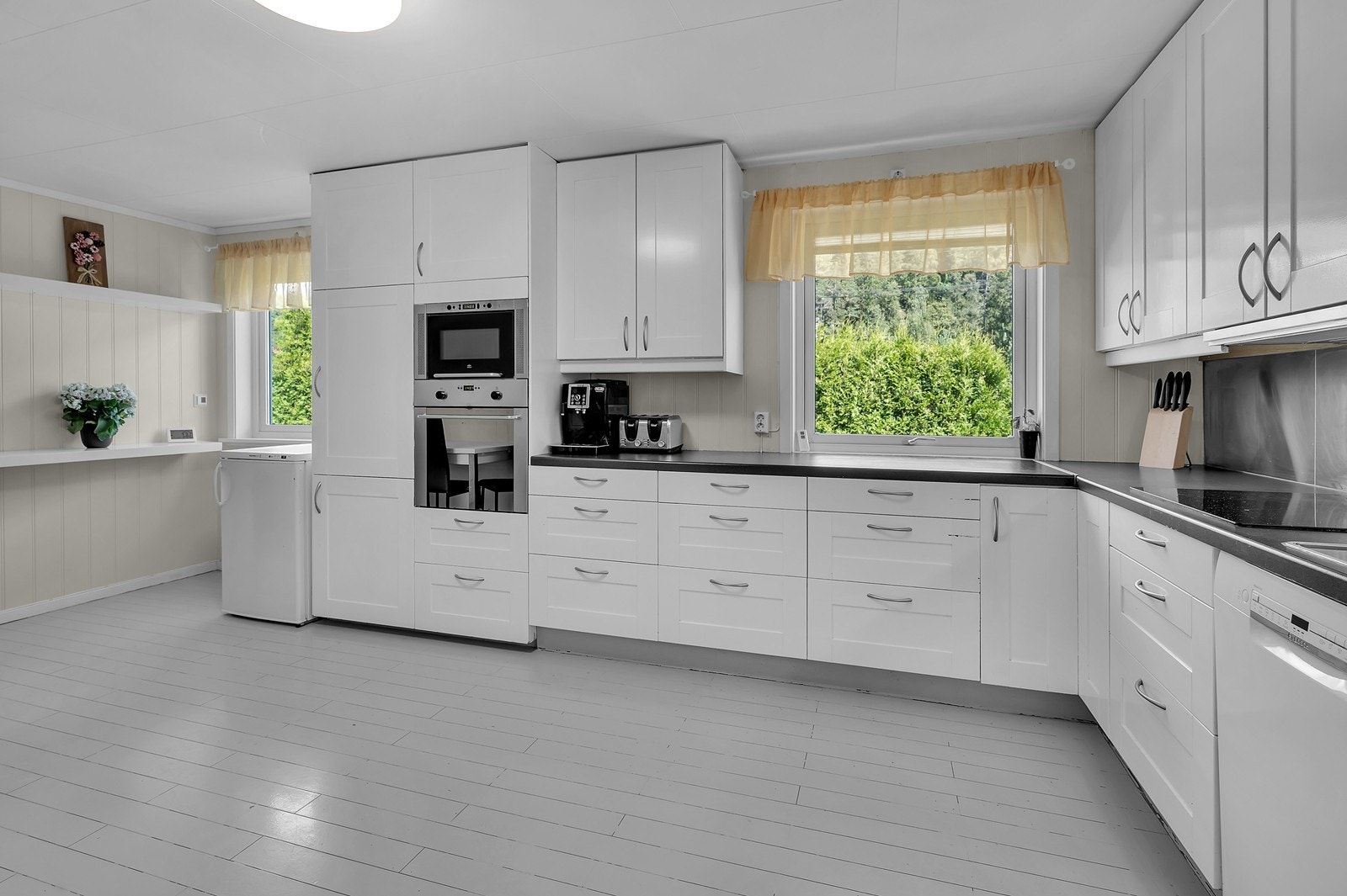 Kjøkkenet er av god størrelse og har rikelig med skap - og benkeplass Galleribilde