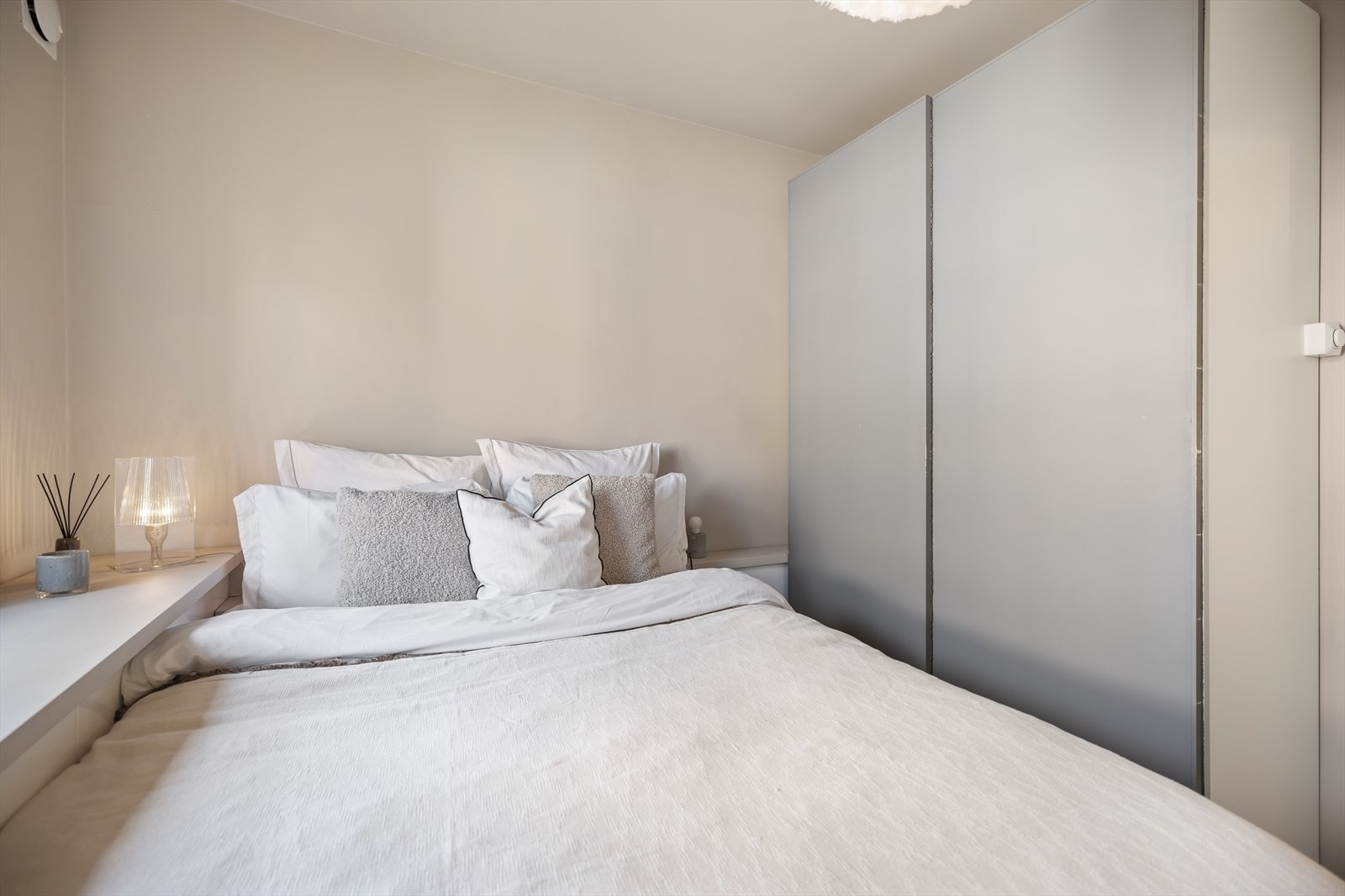 Det er skyvedørsskap langs den ene siden av rommet og lagring i skap på vegg langs vindu. Galleribilde