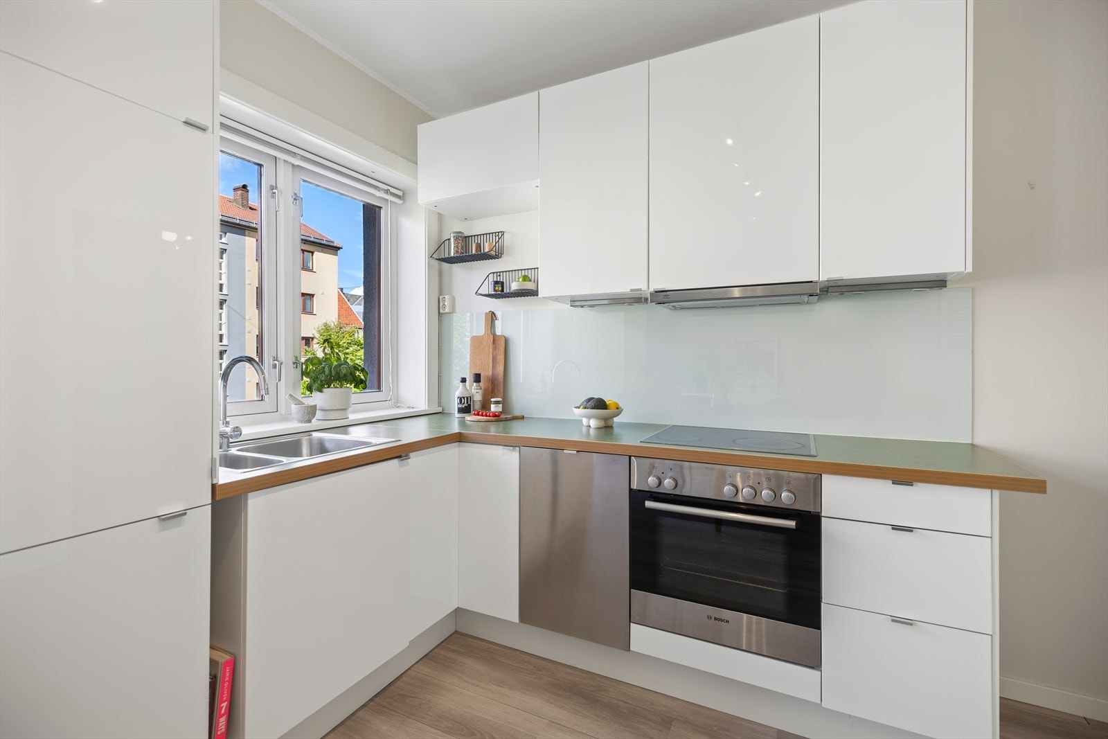 Kjøkkenet består av en lys kjøkkeninnredning fra Ikea med glatte høyglans skapfronter og laminat benkeplate med sprutplate på bakvegg. Galleribilde