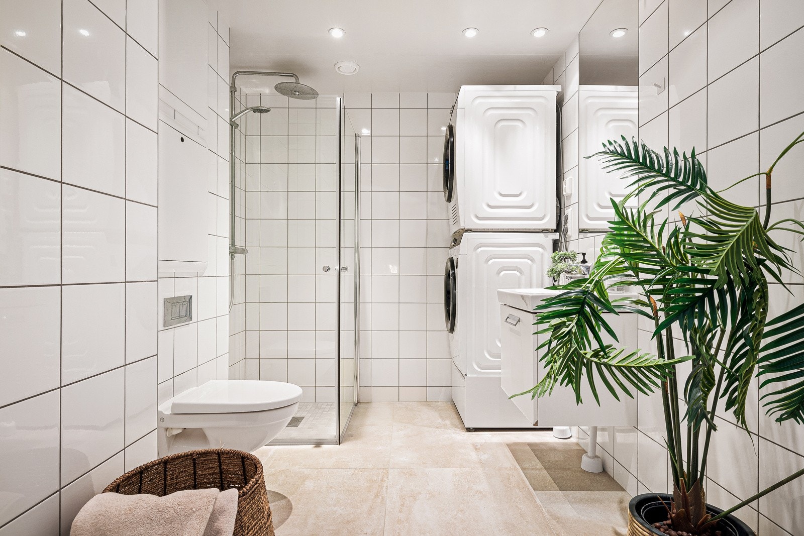 - Badet fremstår lyst og trivelig med fliser på både gulv og vegger, vannbåren gulvvarme, vegghengt toalett, dusj med glassfoldedører, servant med møbel og speil - Galleribilde