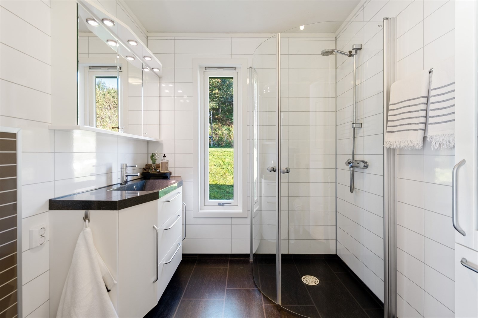 Baderom med dusjhjørne og servant med underskap for lagring Galleribilde