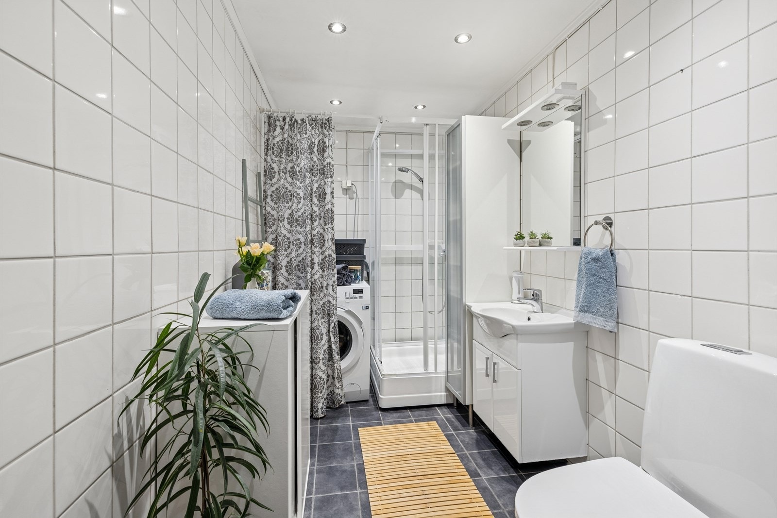 Flislagt baderom med varme i gulvet, innfelte lys i himlingen og opplegg for vaskemaskin. Galleribilde