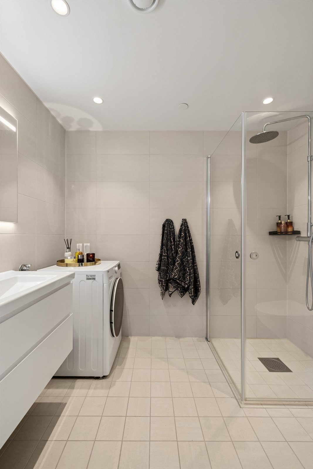 Pent flislagt baderom med varme i gulv, dowlights i taket, opplegg for vaskemaskin og dusjhjørne Galleribilde