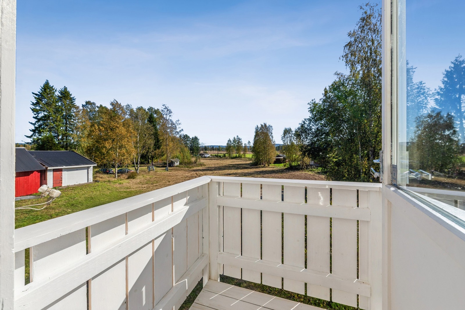 Fra den lille balkongen i andre etasje har du utsyn over tomten og landlige omgivelser. Galleribilde