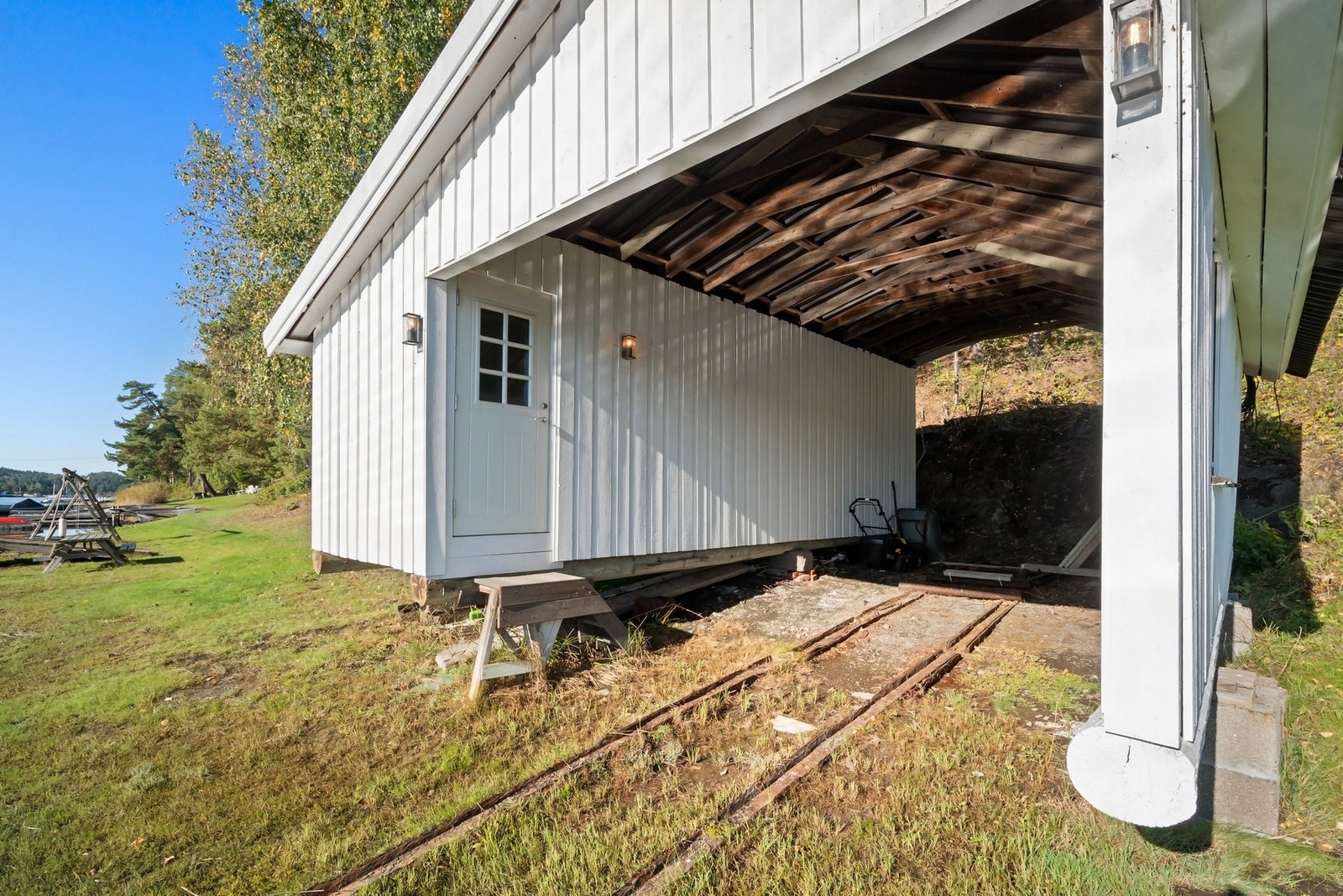 Det sjarmerende båthuset ligger praktisk til ved vannkanten og gir en trygg og skjermet lagringsplass for båt og utstyr. Galleribilde