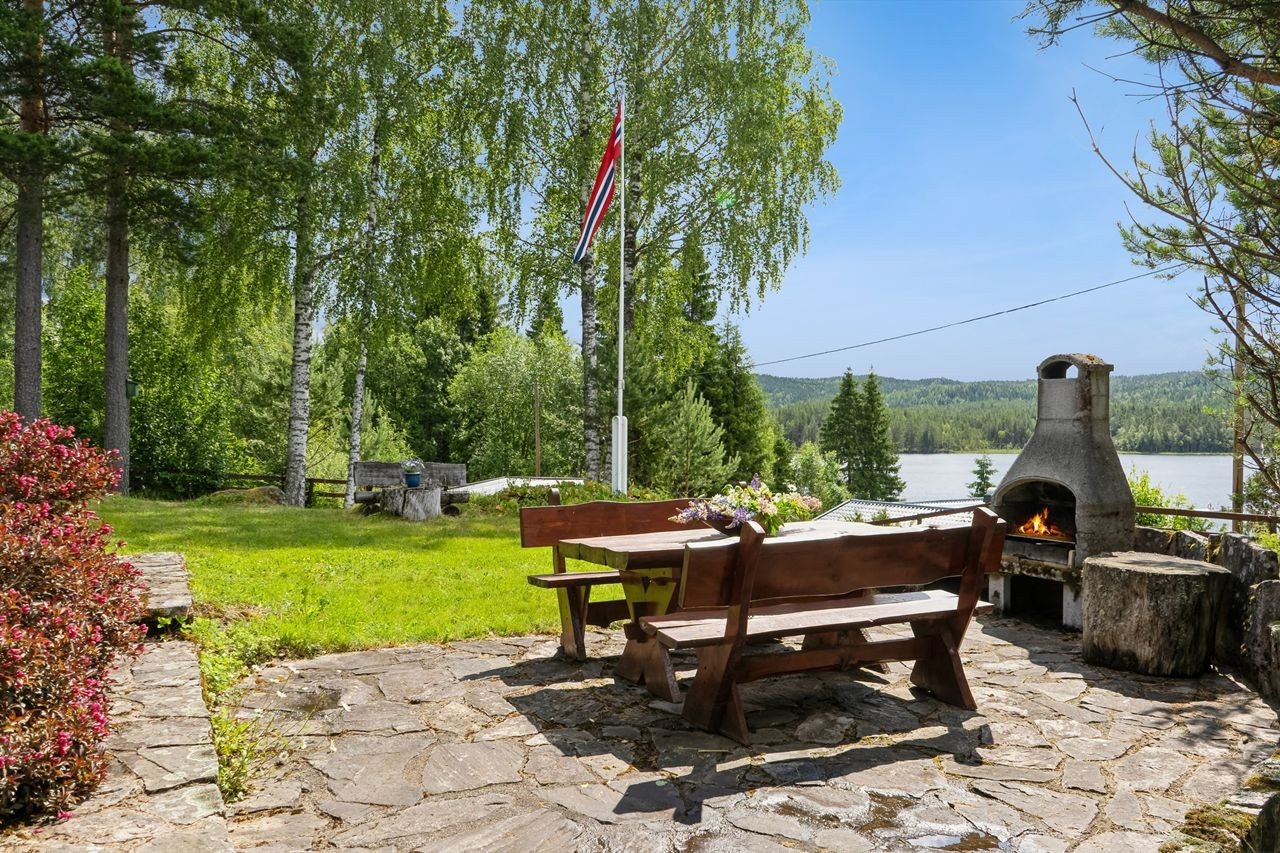 Steinbelagt uteplass med utepeis inviterer til grillkvelder under åpen himmel på vakre Finnskogen. Galleribilde