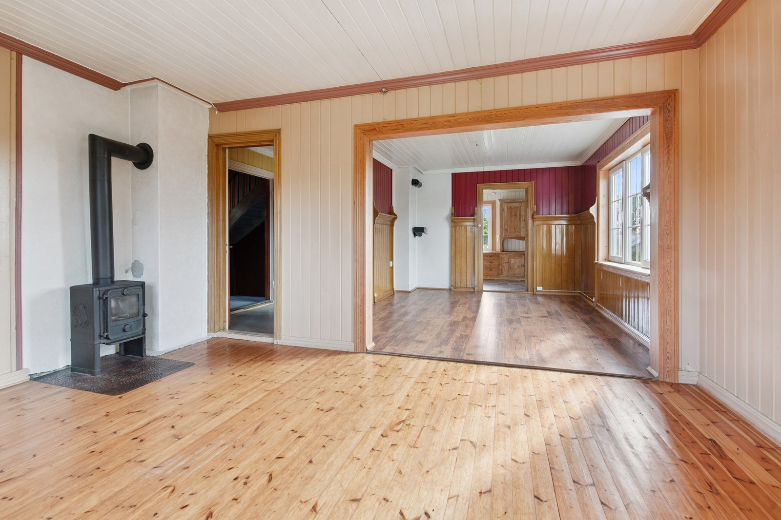 Rommet har et klassisk ildsted for ekstra varme og en åpen løsning mot spisestuen. Galleribilde