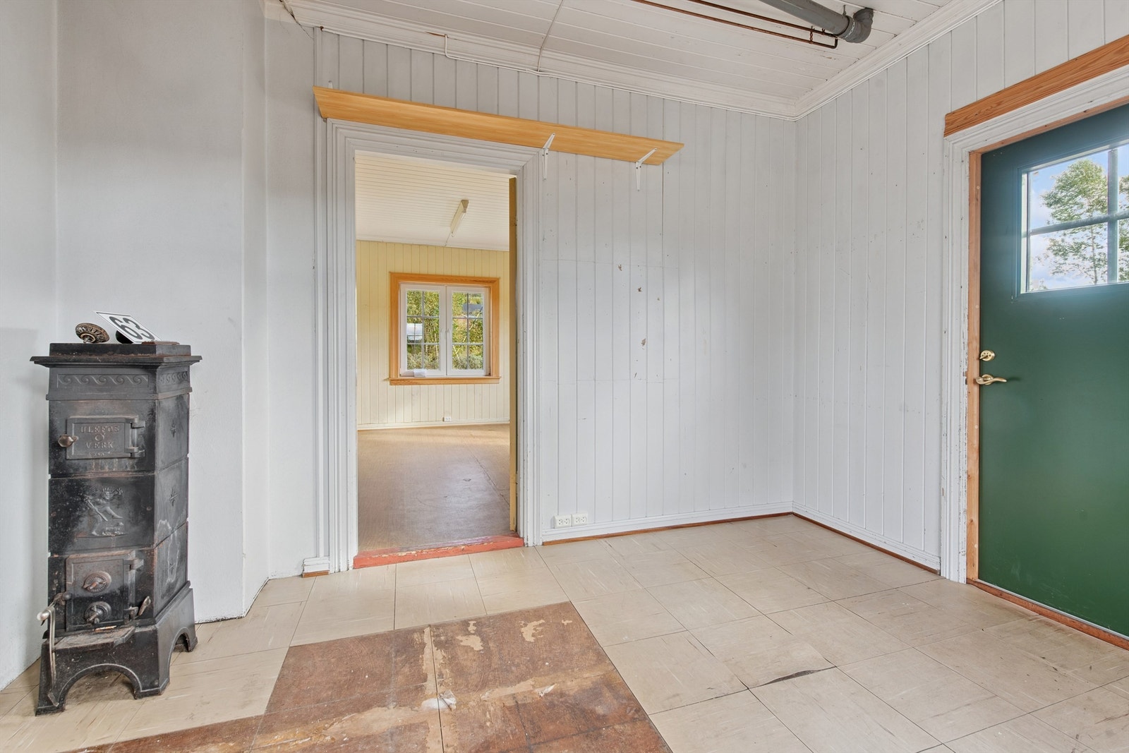 Et av rommene har et eldre ildsted og utgang til eiendommens sørlige side via en laminert ytterdør. Galleribilde