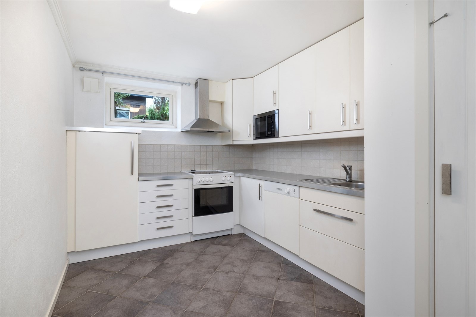 Det er et innredet kjøkken med glatte fronter og benkeplate i laminat. Galleribilde