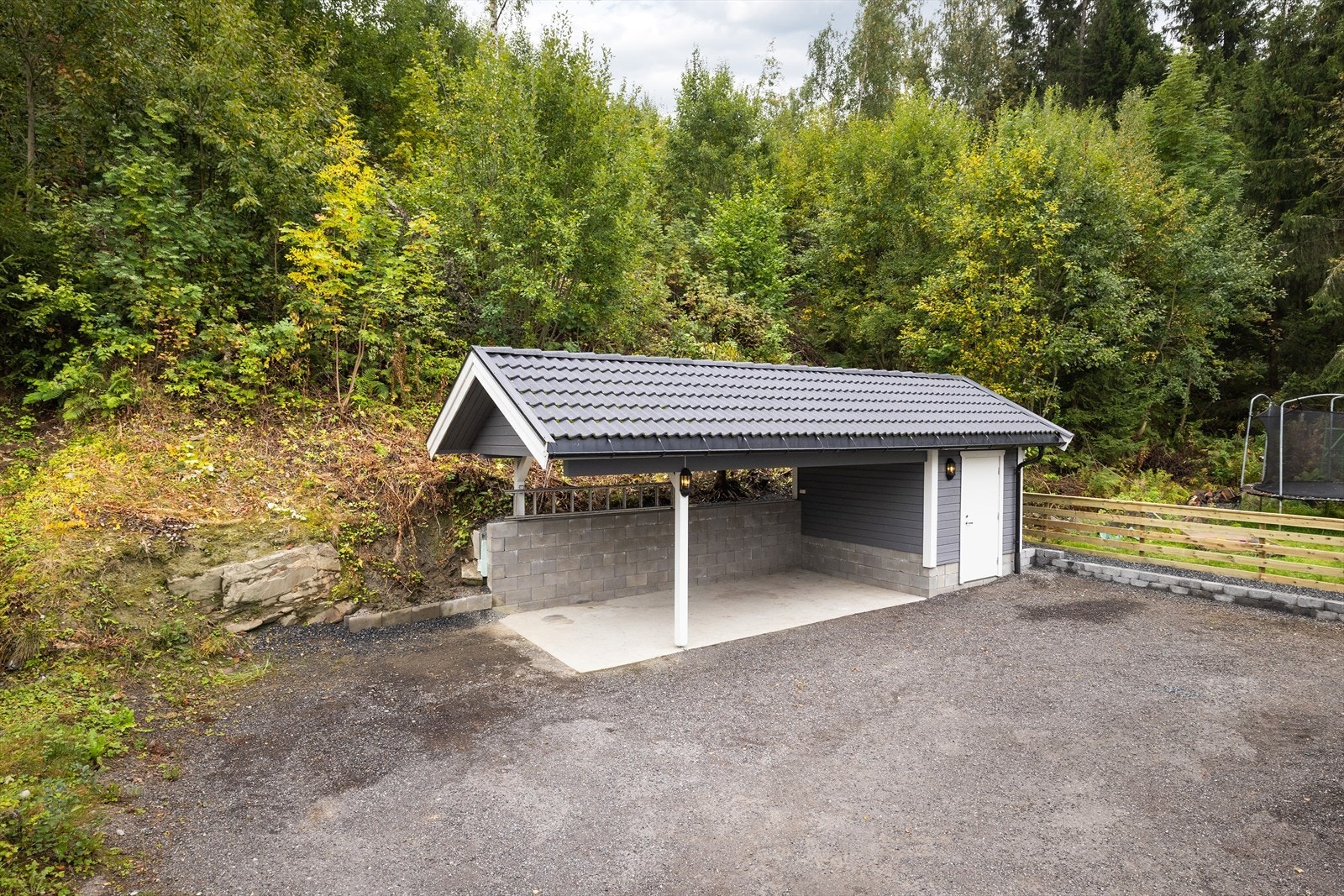 Boligen har gode parkeringsmuligheter i carport fra 2019 og gruset gårdsplass. Galleribilde