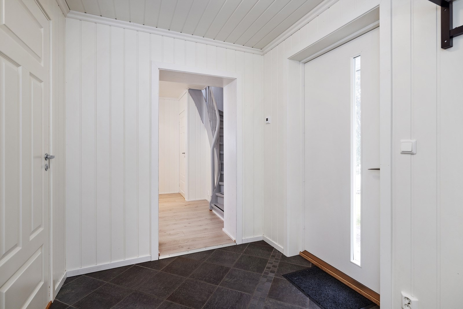 Entréen er flislagt med mulighet for oppheng av yttertøy. Galleribilde