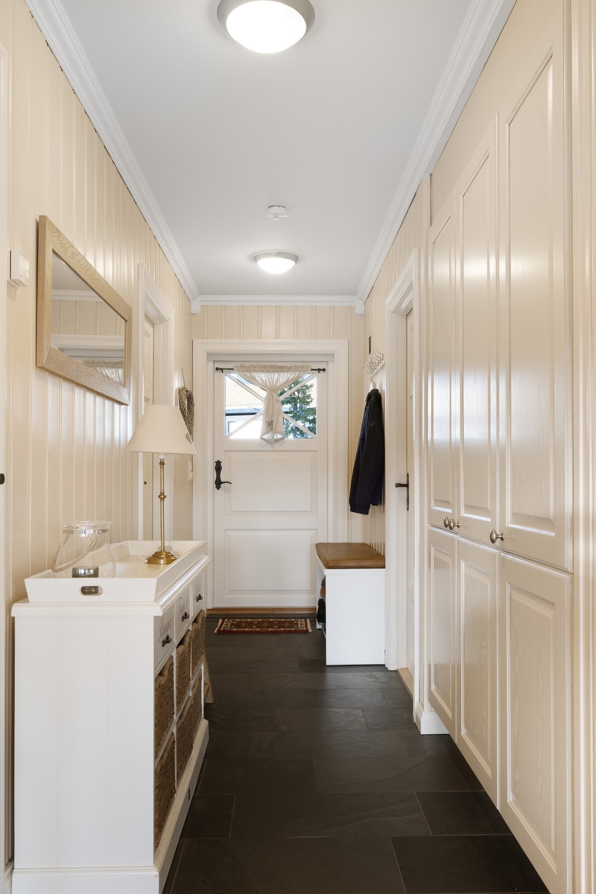 Romslig og innbydende entré med praktisk garderobeskap som gir godt med oppbevaringsplass til yttertøy og sko. Galleribilde