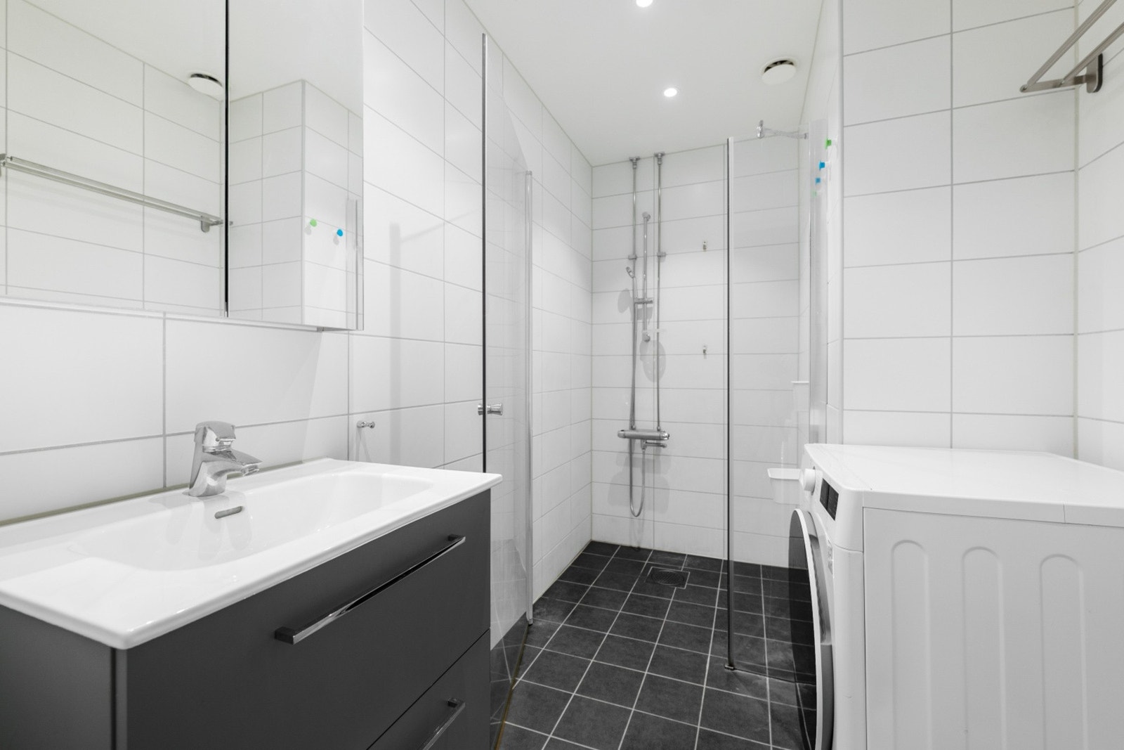 Badet er innredet med innredning m/ heldekkende servant m/ bl.batteri, dusjhjørne, overskap m/ speil og lys. Opplegg for vaskemaskin. Galleribilde