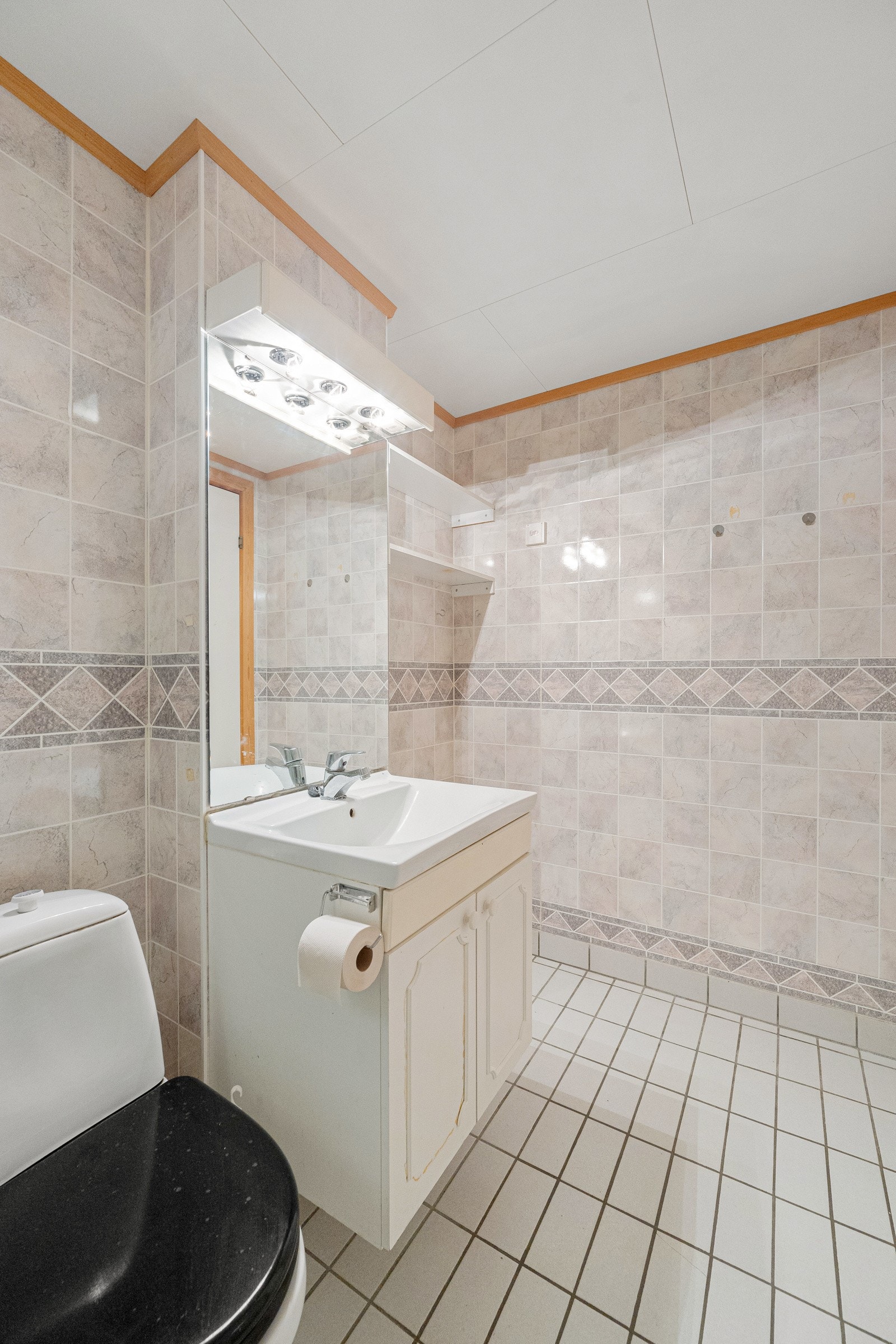 Badet er innredet med servant med skap, WC, opplegg for vaskemaskin og avgrenset dusjsone Galleribilde