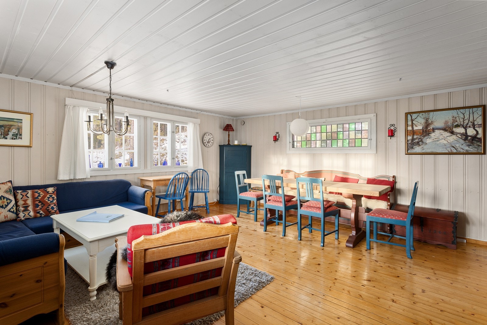 Stuen er lys og luftig med lysmalt panel på vegger og tak. Galleribilde