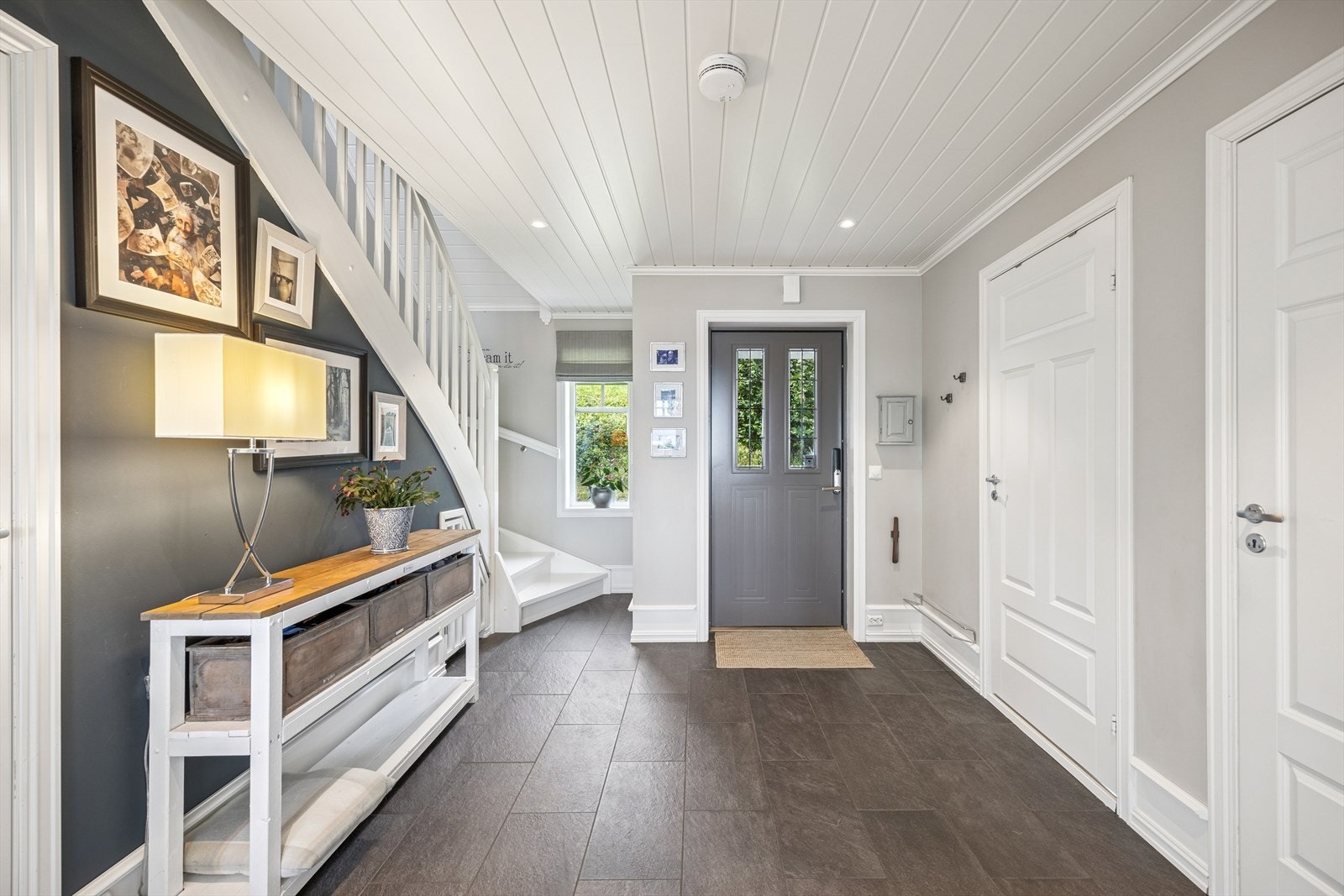 Man blir ønsket velkommen inn i en lys og luftig hall med praktiske fliser på gulvet. Galleribilde