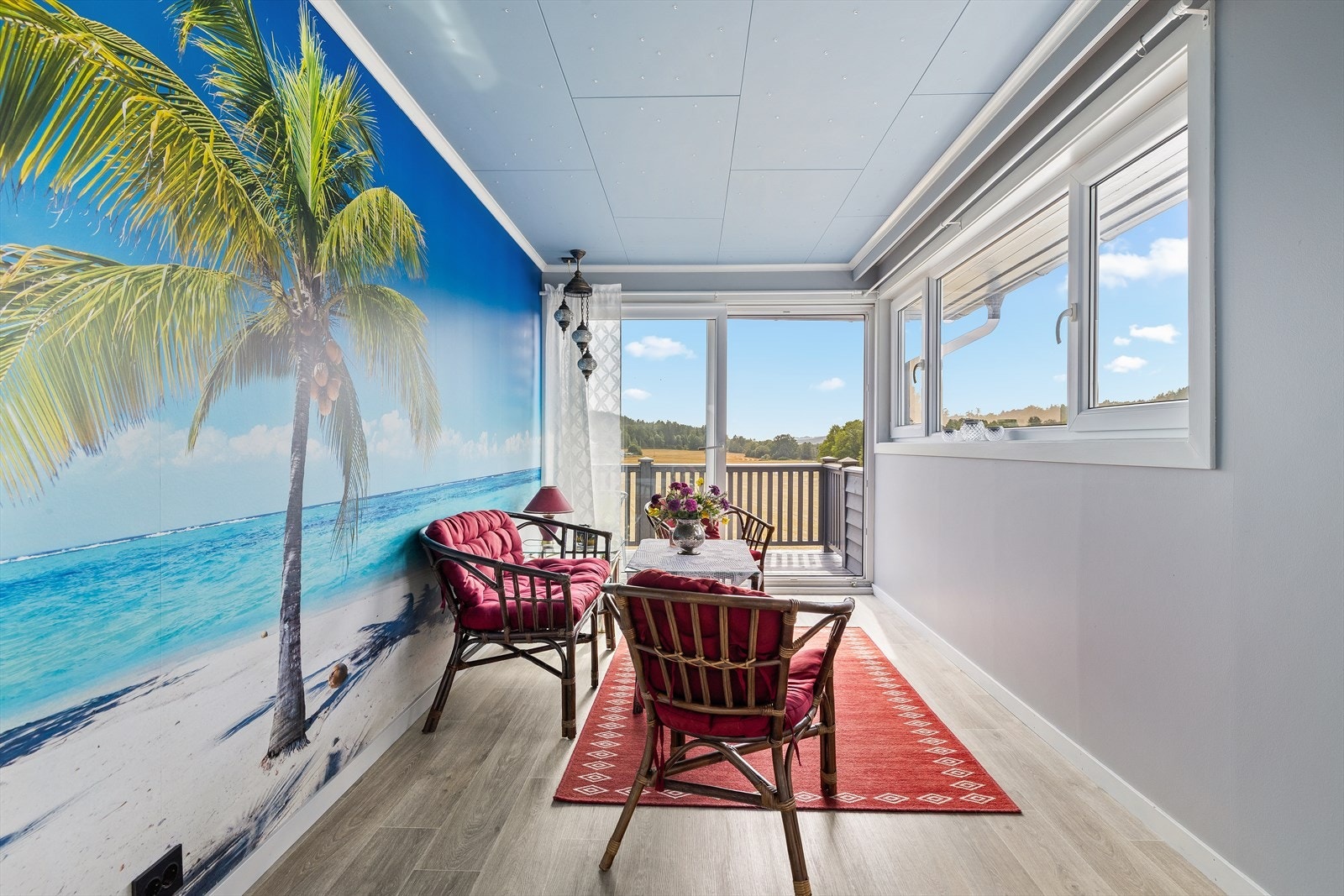 Den innglassede balkongen har plass til en liten sofagruppe. Her kan du kose deg året rundt, uansett vær Galleribilde