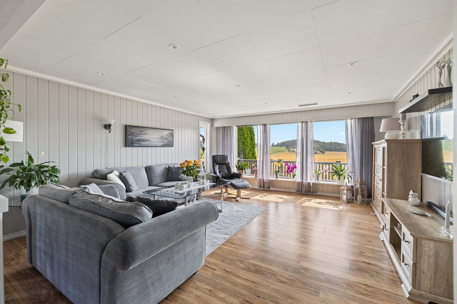 Lys og romslig stue med store vindusflater som sørger for naturlig lysinnslipp Galleribilde