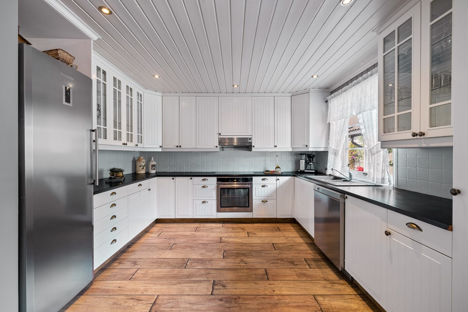 Kjøkkenet har profilerte fronter og benkeplaten er av heltre Galleribilde