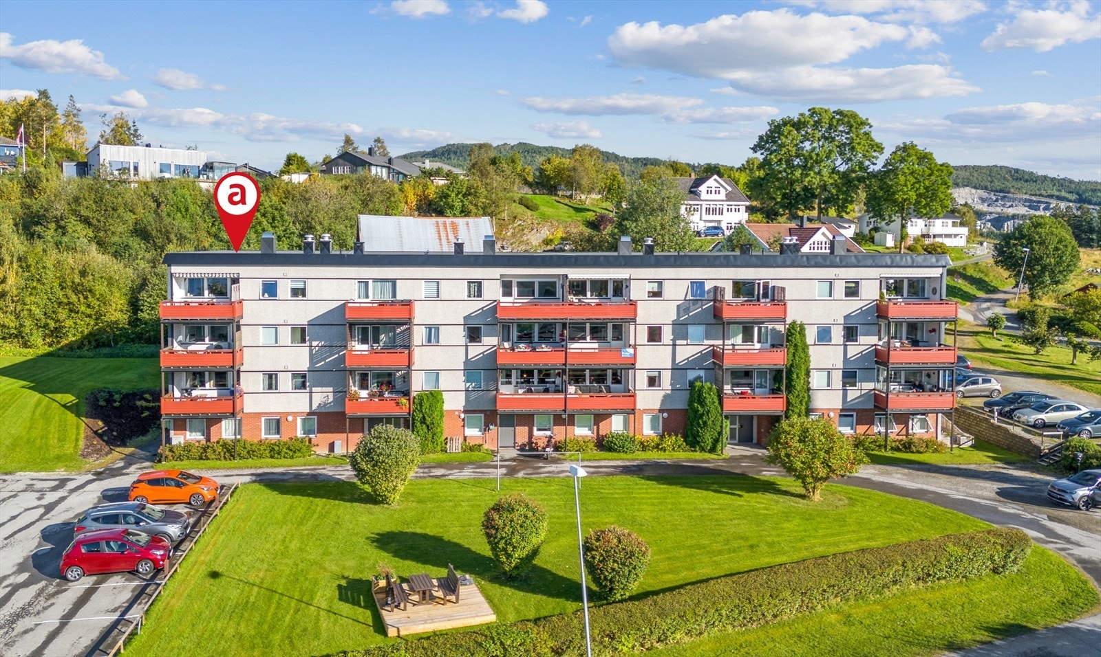 Velstelt fellesområde med grøntarealer og parkering. Galleribilde