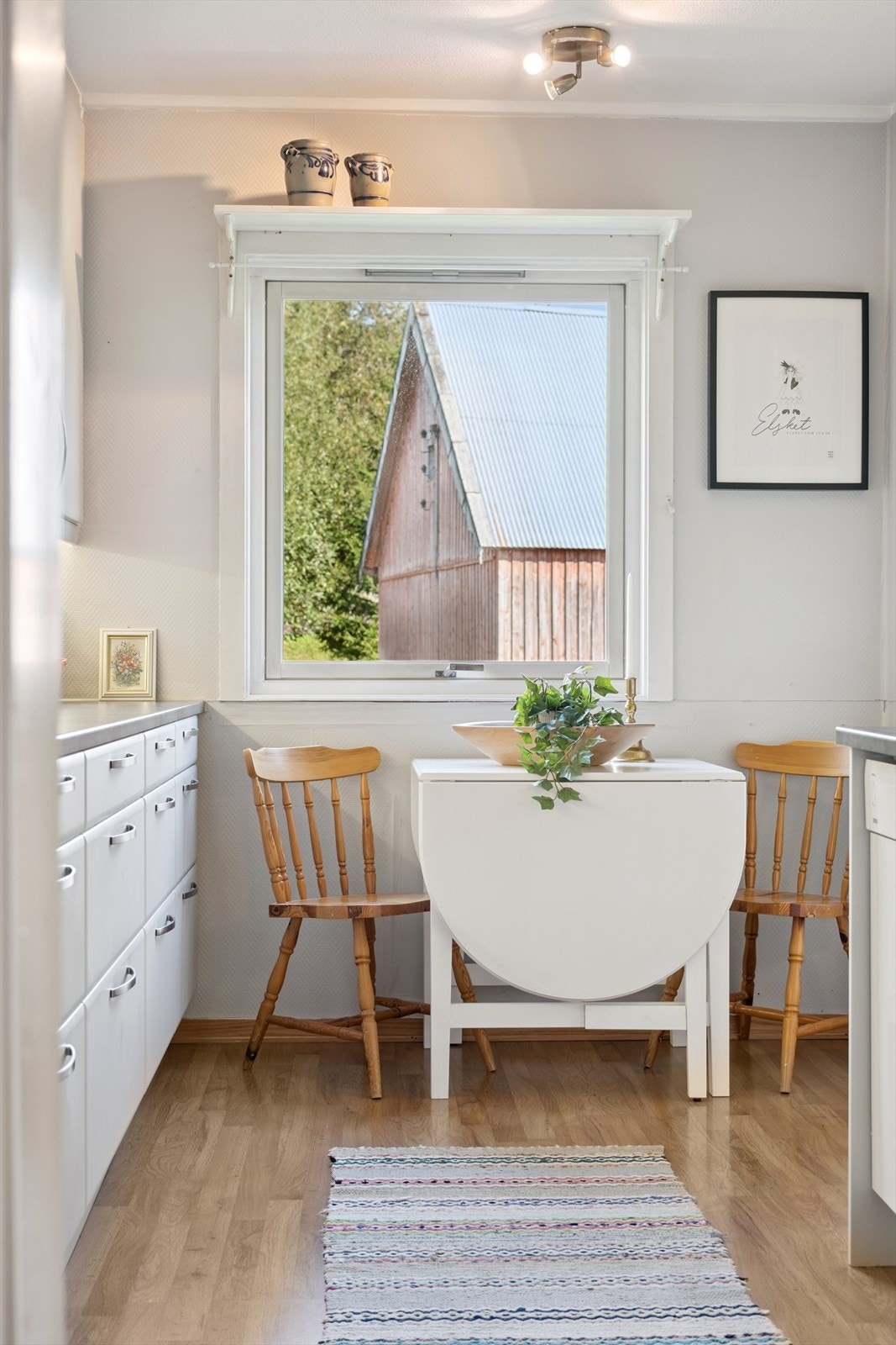 Koselig spiseplass på kjøkkenet med utsikt ut mot grøntområder. Galleribilde