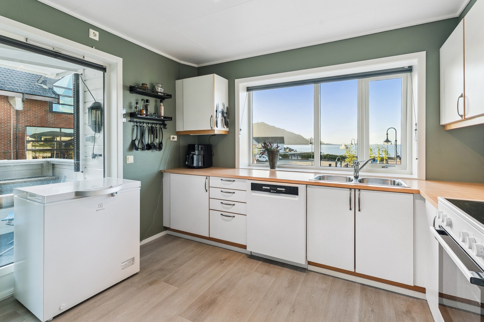 Kjøkken med kjøleskap, komfyr og oppvaskmaskin som kan følge handelen. Galleribilde