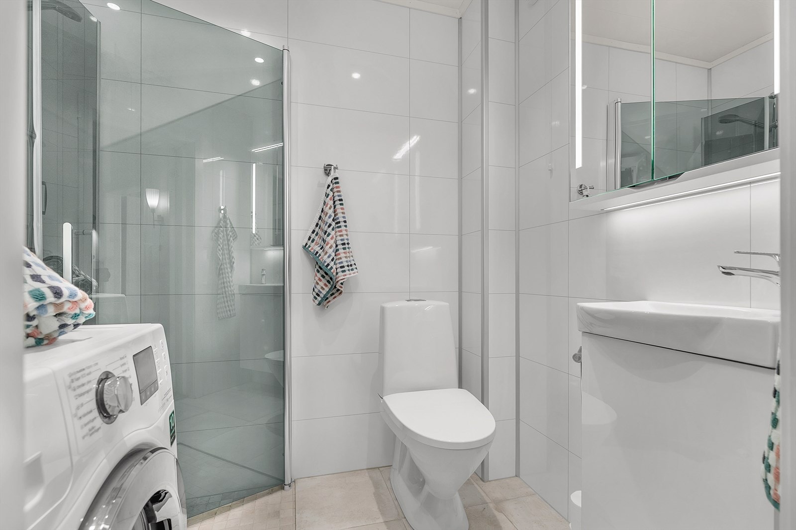 Bad i tidløse farger med flislagt gulv med varmekabler. Galleribilde