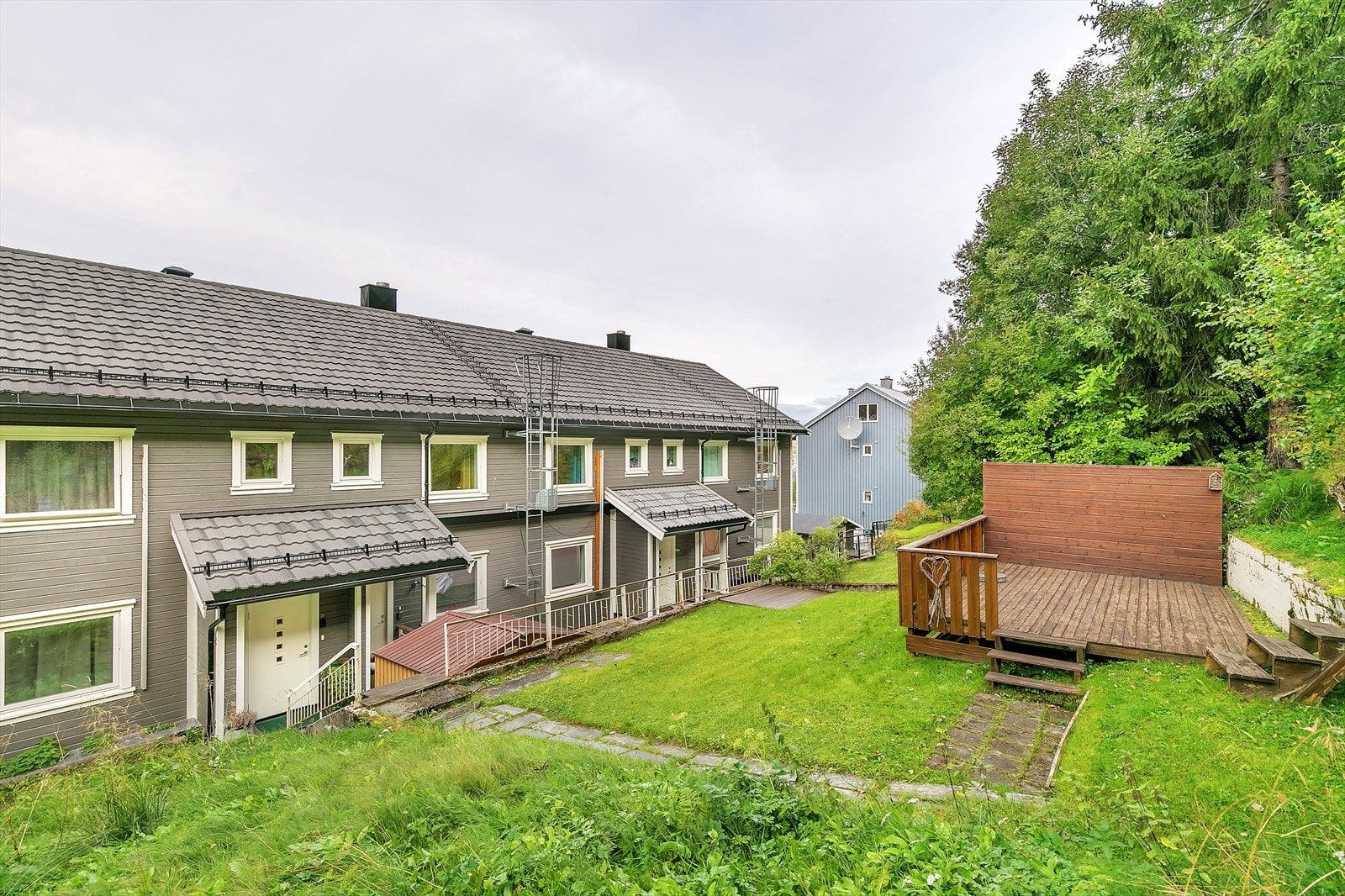 Tomten er opparbeidet med plenareal, plattinger og forstøtningsmurer. Galleribilde