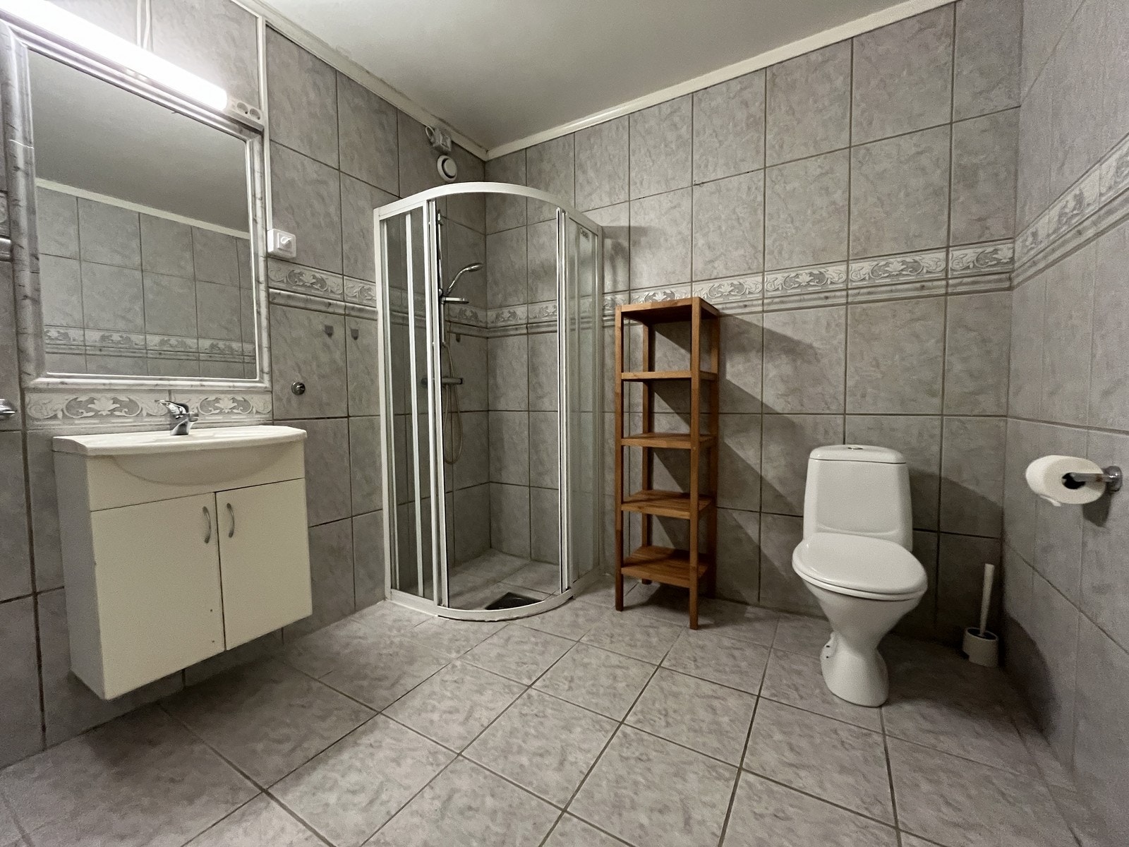 Pent flislagt bad med hjørnedusj, servant m/innredning og toalett Galleribilde