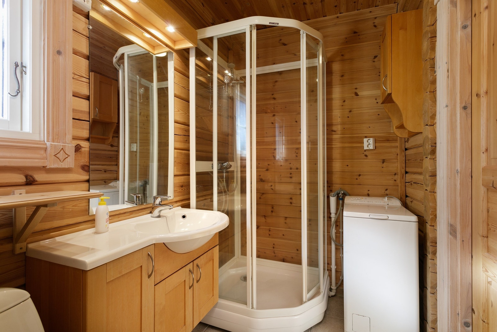 Bad med innredning, dusjkabinett, toalett og vaskemaskin Galleribilde