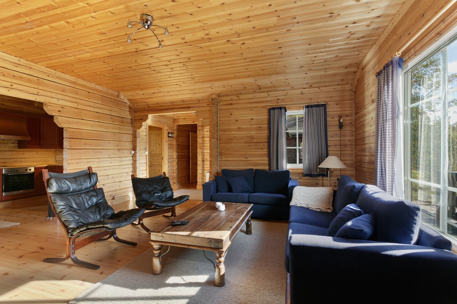 Stue i hovedhytten med åpen løsning mot kjøkken og spisestue Galleribilde