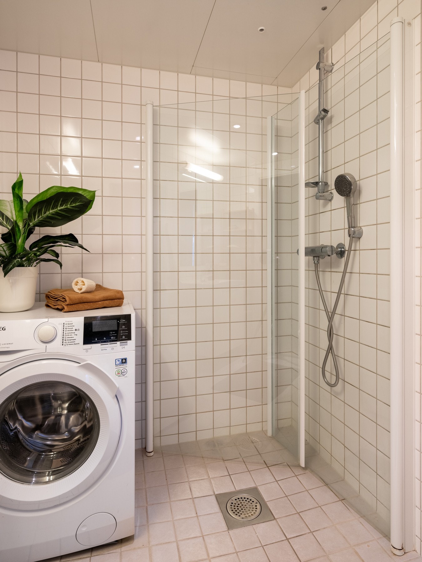 Videre er det dusjhjørne med svingbare dører som frigjør plass på gulvet. Badet har opplegg for vaskemaskin. Vaskemaskinen medfølger. Galleribilde