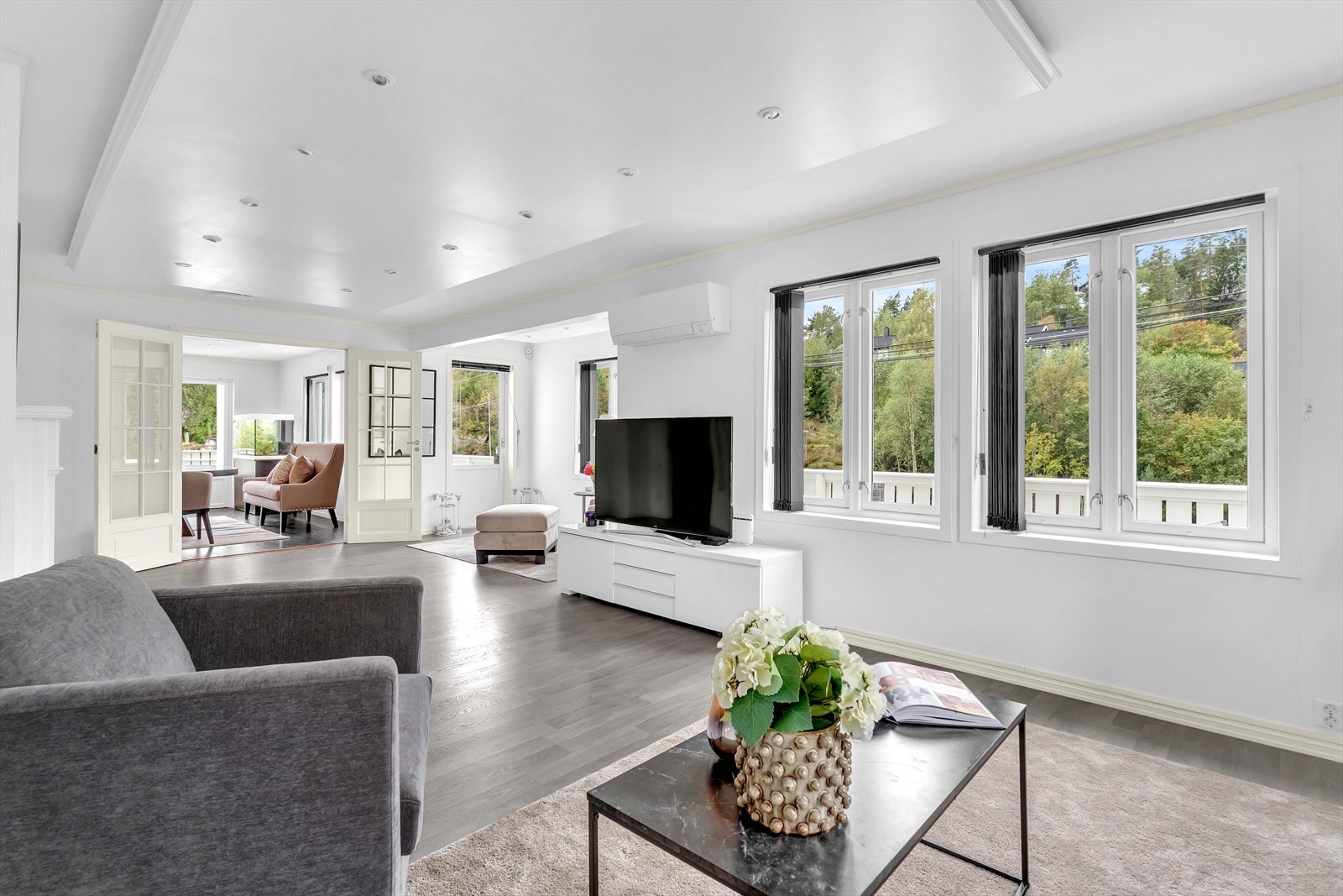 De store vinduene inviterer den fine, grønne utsikten inn i stuen. Galleribilde