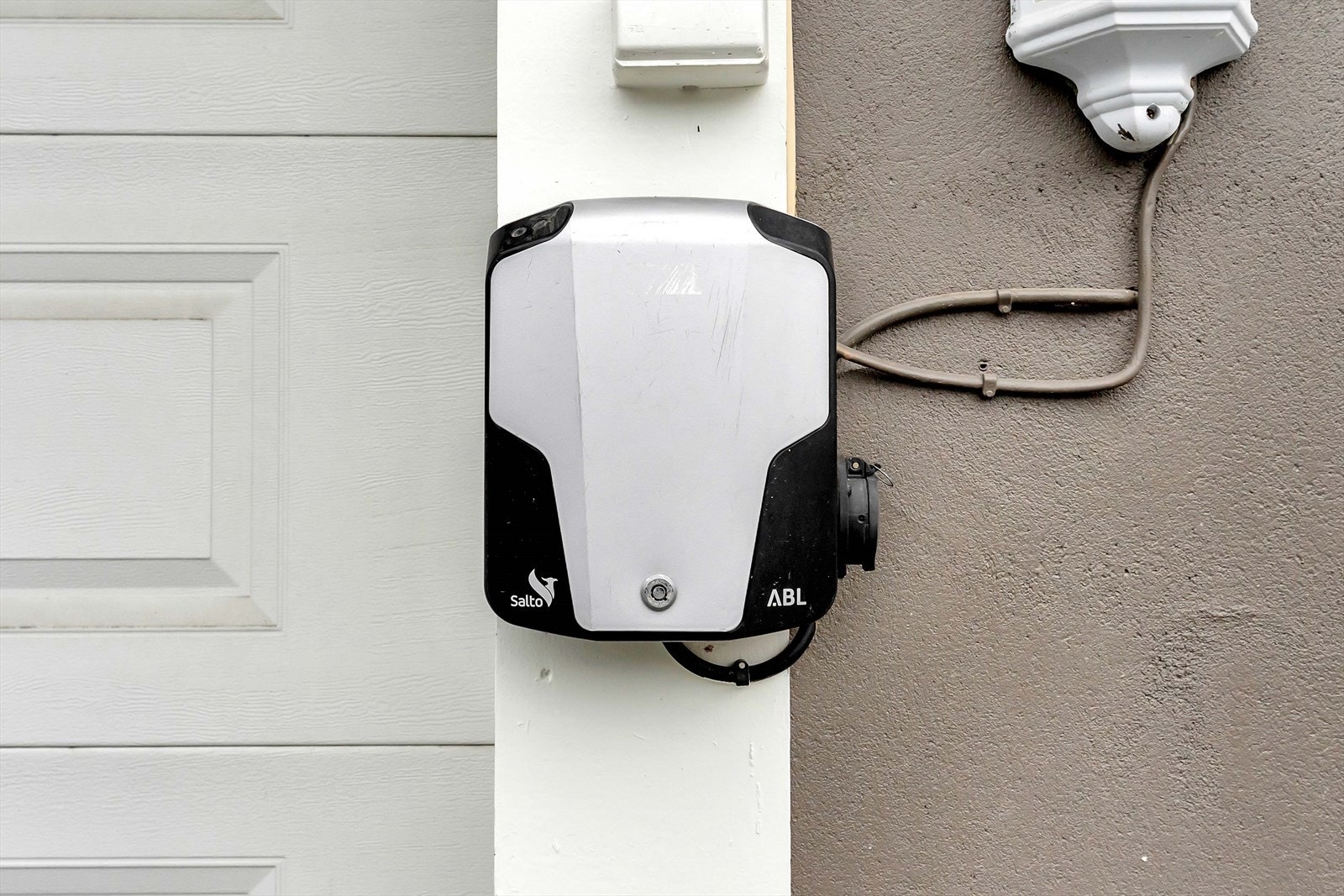 Elbil-lader er montert på husveggen. Galleribilde