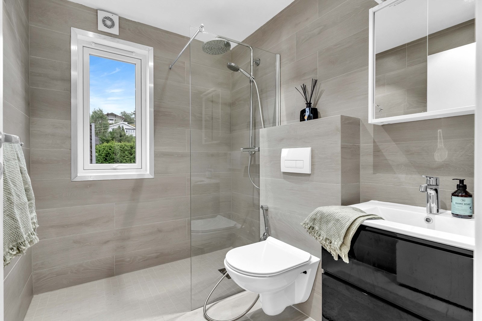 Moderne og delikat bad utført i en tidløs stil med flislagte gulv og vegger. Galleribilde