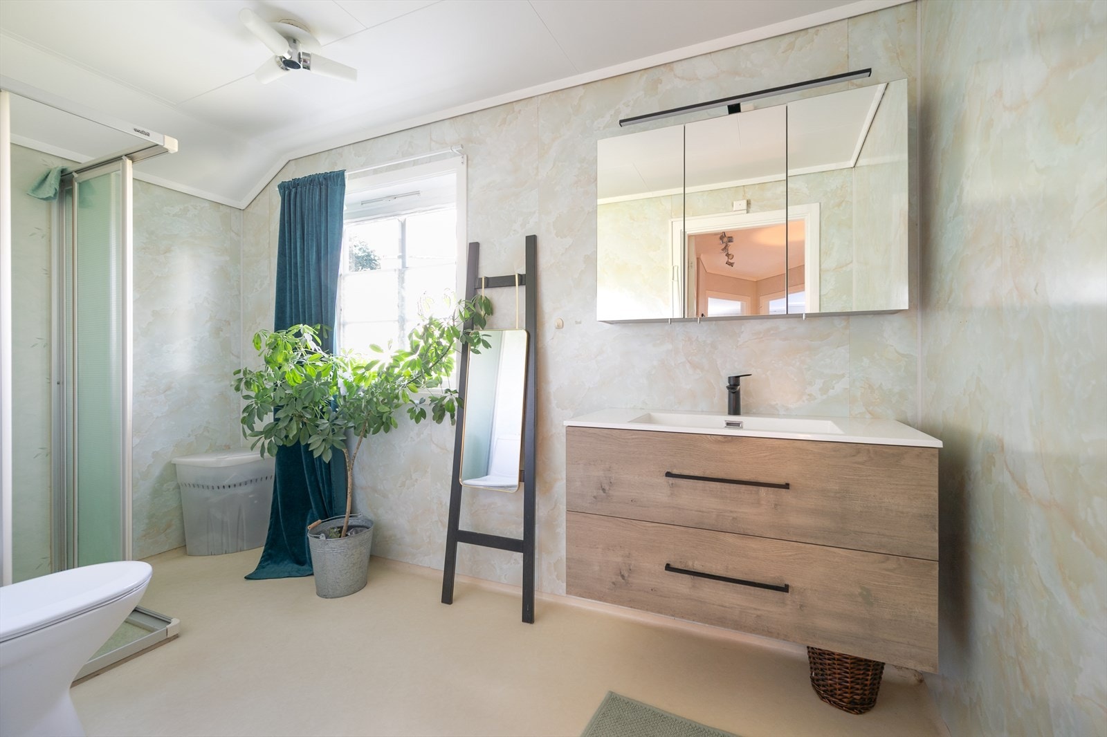 Badet i 2.et. har belegg og baderomsplater. Servant med armatur og speilskap fra 2025. Galleribilde