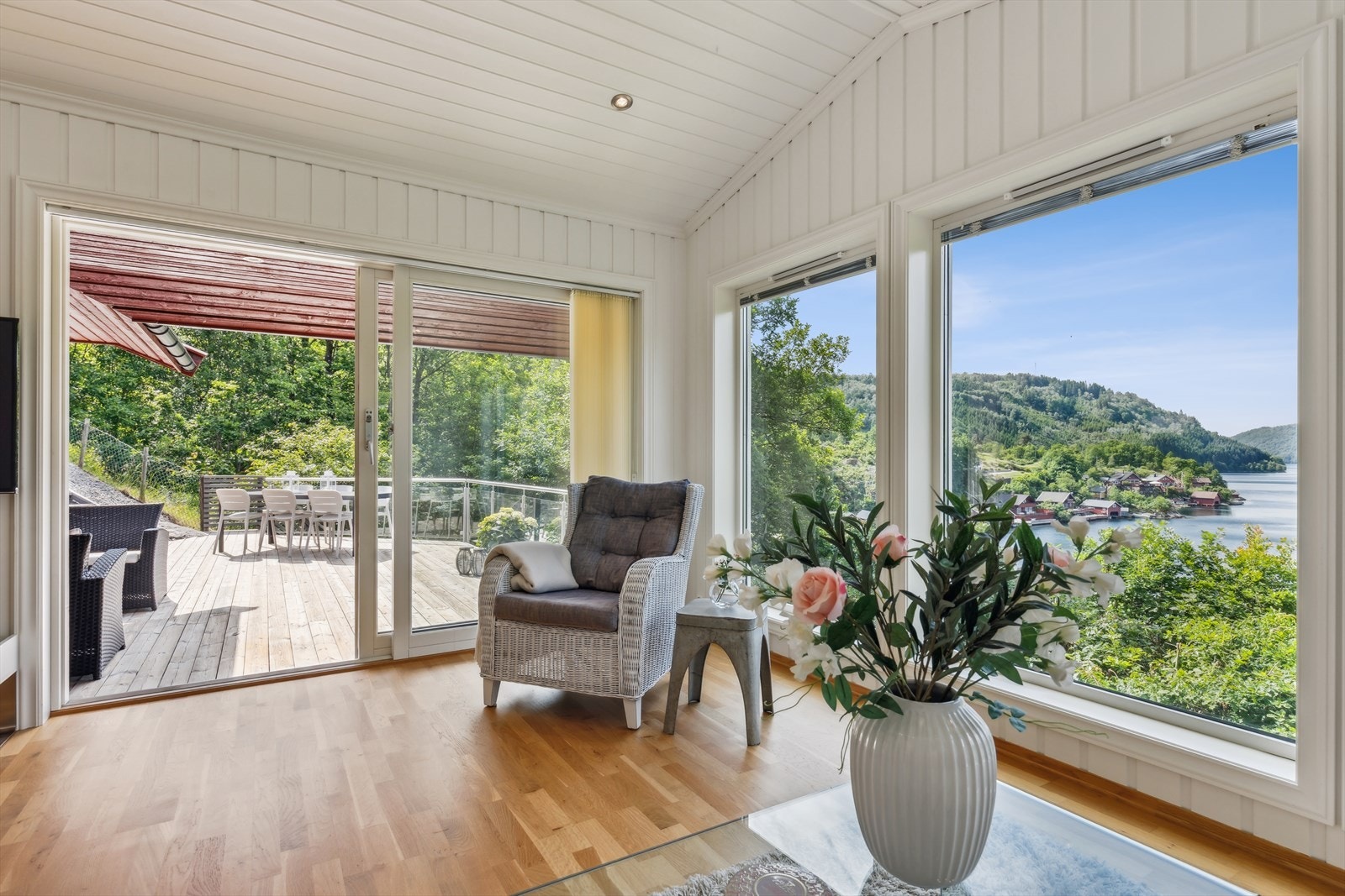 Stor skyvedør ut til en solrik terrasse som er er delvis overbygd. Galleribilde