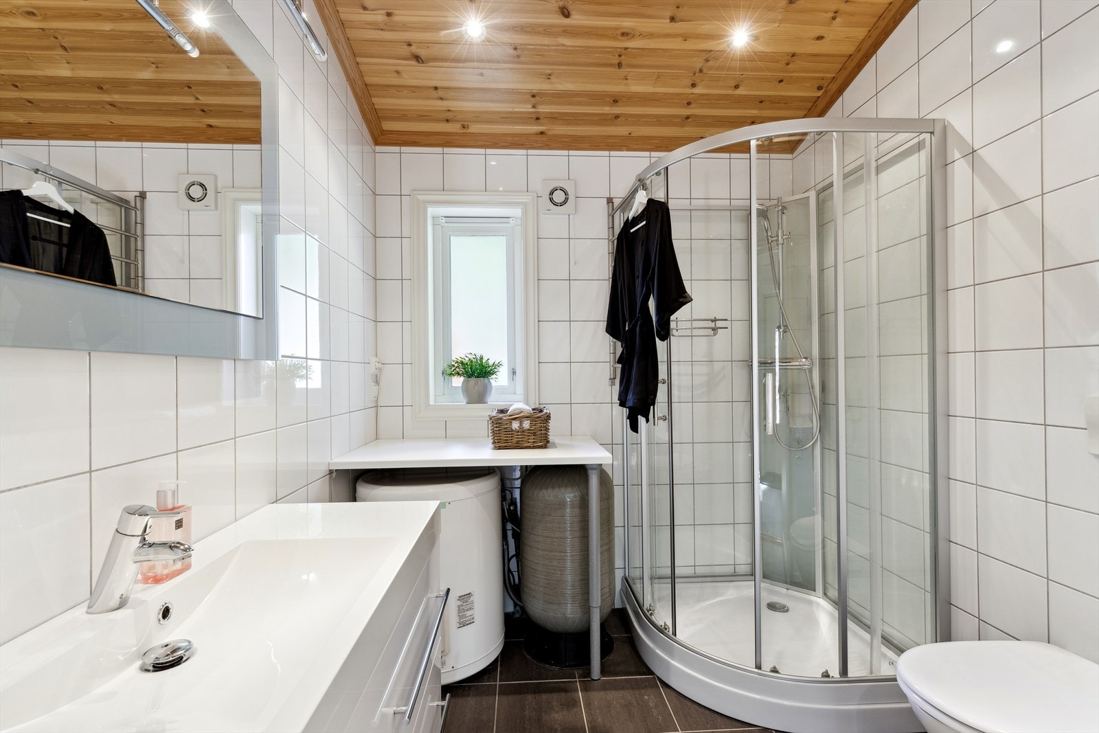 Lyst og moderne bad med dusjkabinett, baderomsinnredning og toalett. Varmekabler i gulv. Galleribilde