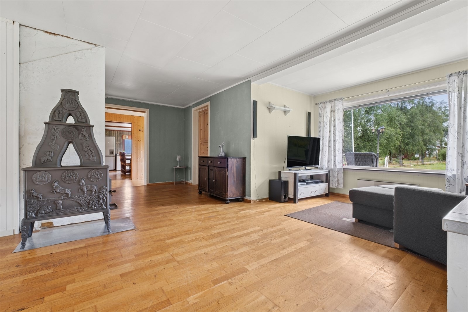 Her har man god plass til en stor sofagruppe. Det er også en vedkamin som egner seg godt på kalde vinterkvelder. Galleribilde
