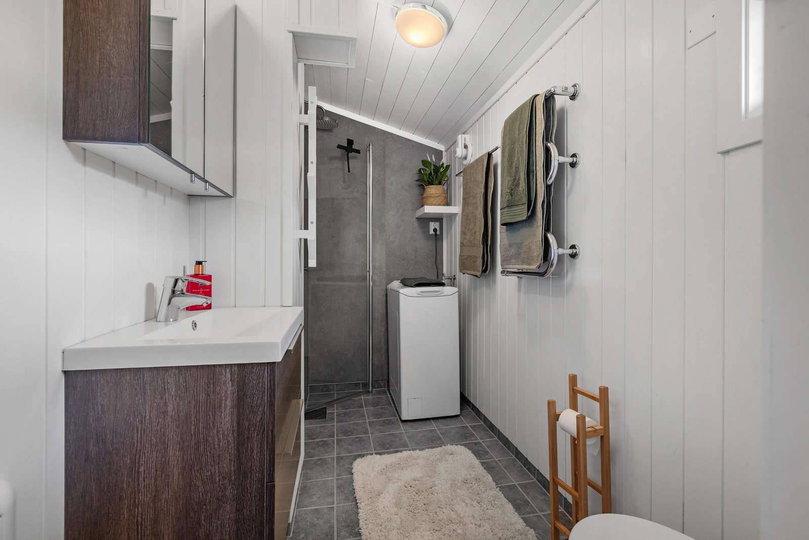 Badet er oppgradert og holder en moderne standard med fliser, varmekabler, dusjhjørne og servantmøbel. Galleribilde