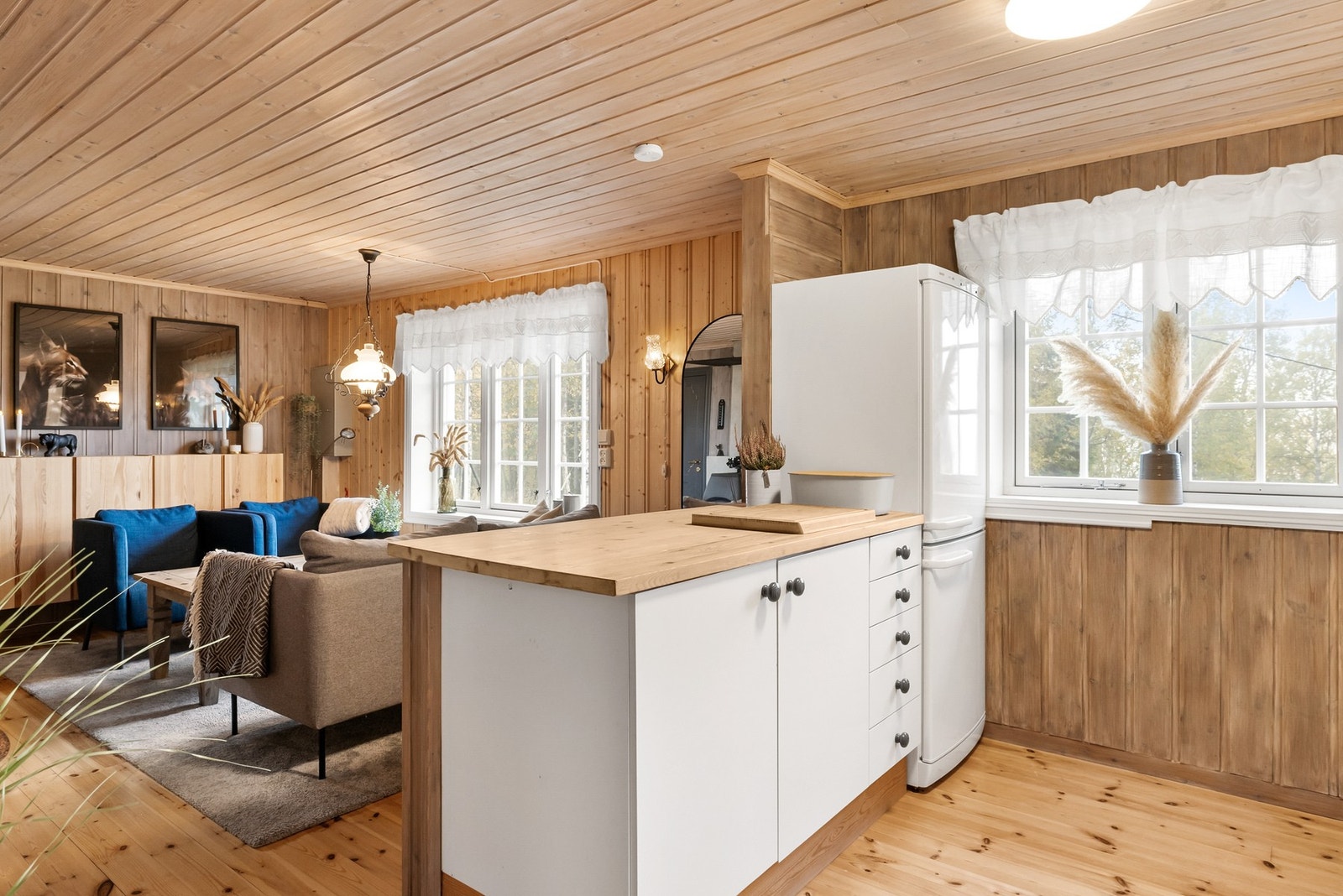 Praktisk hyttekjøkken med enkel kjøkkenøy som gir ekstra benkeplass og sosial sone Galleribilde