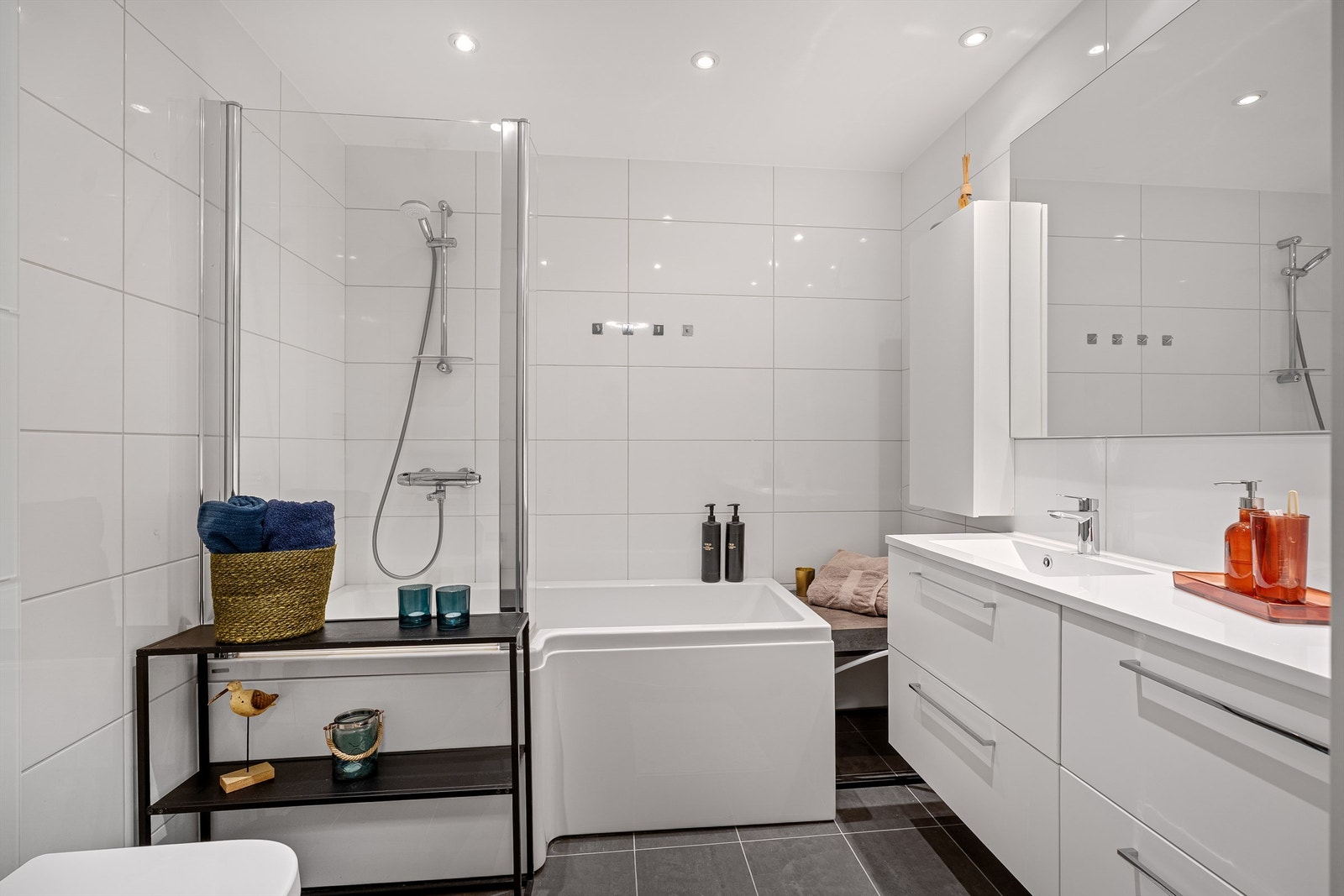 Stilrent bad med flislagte overflater og lyse fargetoner. Galleribilde