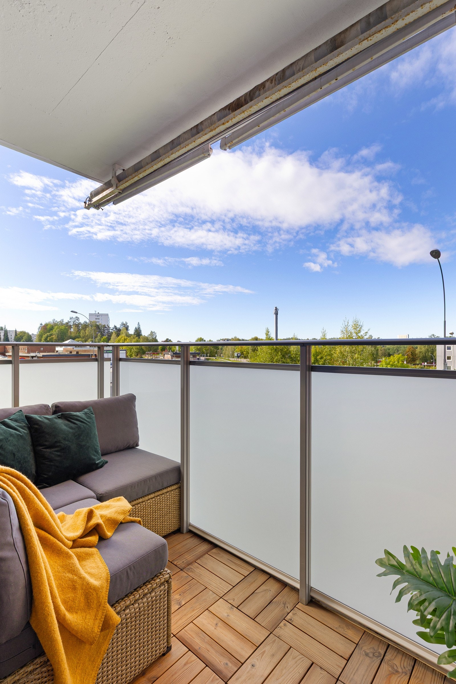 Balkongen er belagt med tretremmer og har rekkverk av stålkonstruksjoner og glass - markise er montert Galleribilde