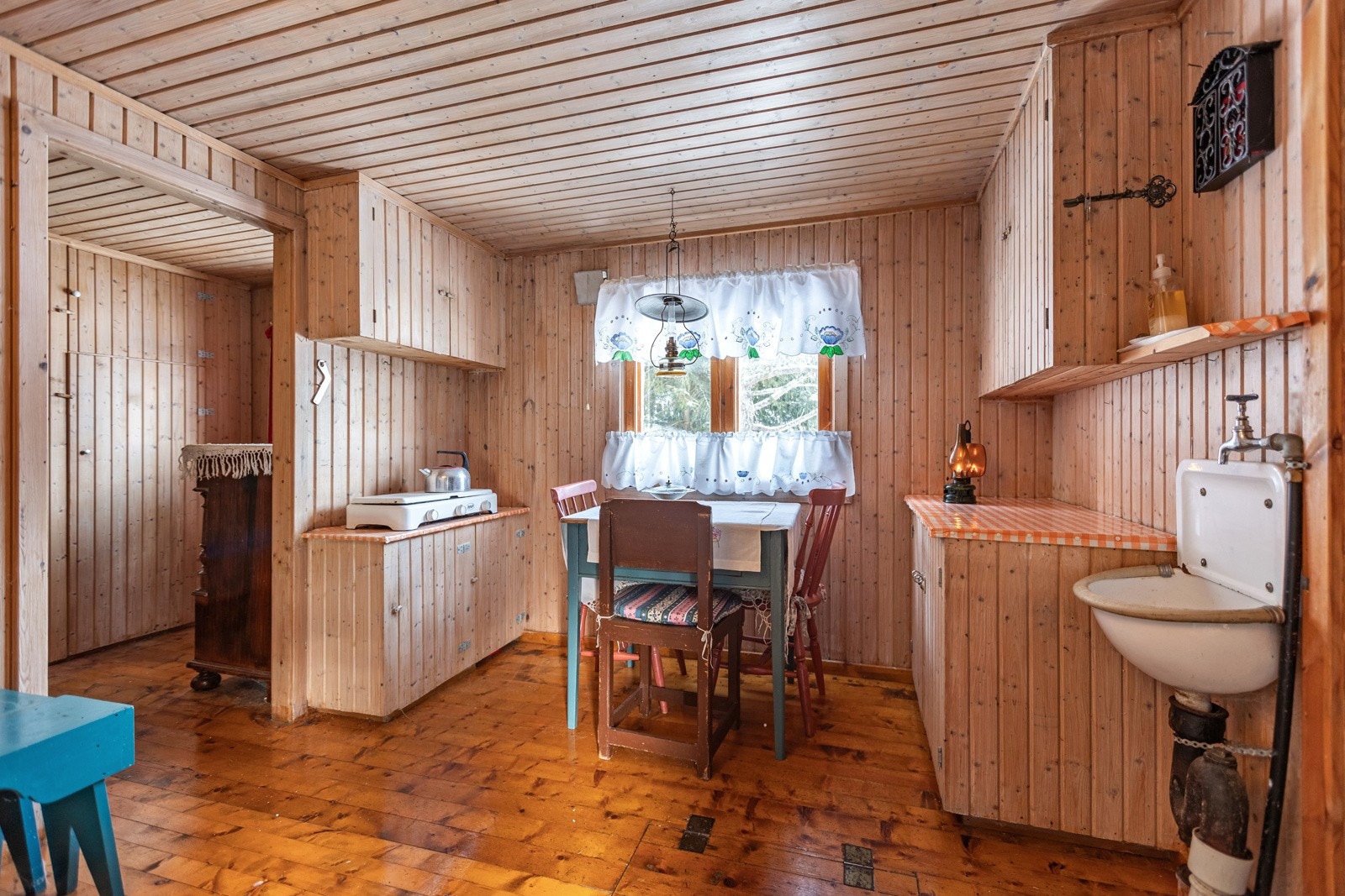 Hytta har et enkelt kjøkken som er innredet med profilerte fronter og en benkeplate av tre dekket med plast. Galleribilde