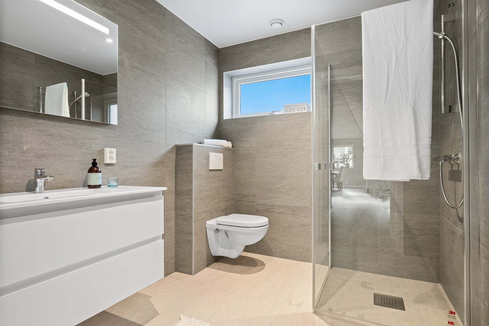 Badet har dusjhjørne med glassvegger og vegghengt toalett. Galleribilde