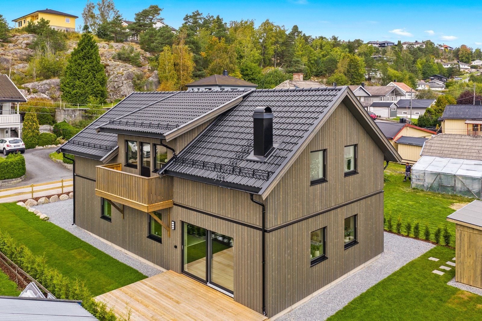 Eiendommen er pent opparbeidet med plen og busker. Galleribilde